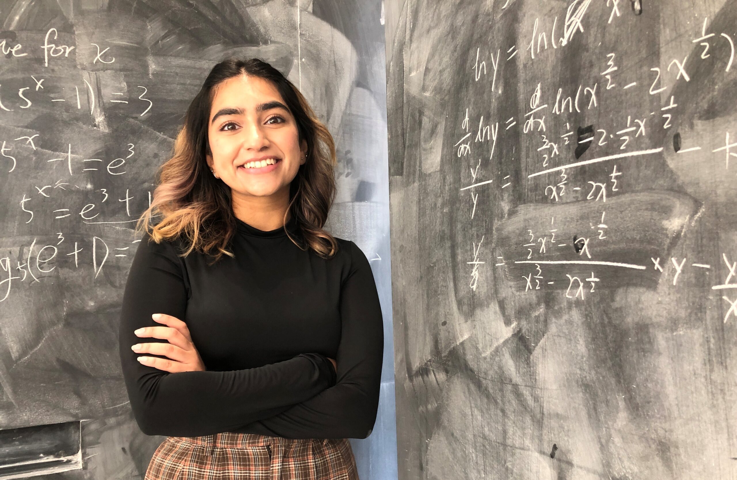 Student in front of chalk board.